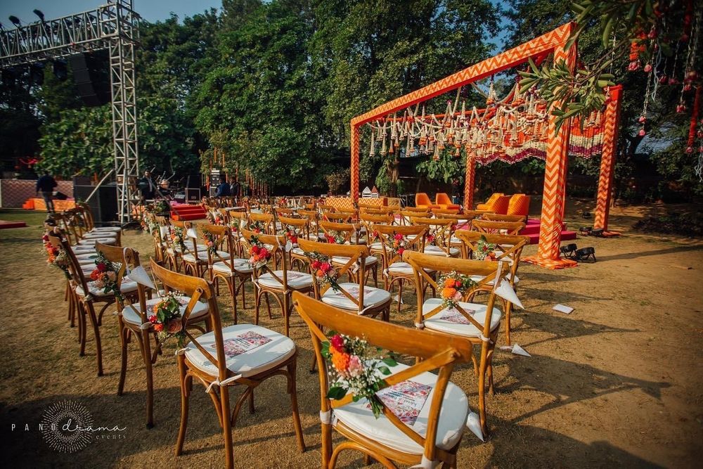 Photo of simple orange mandap with chair decor for intimate wedding