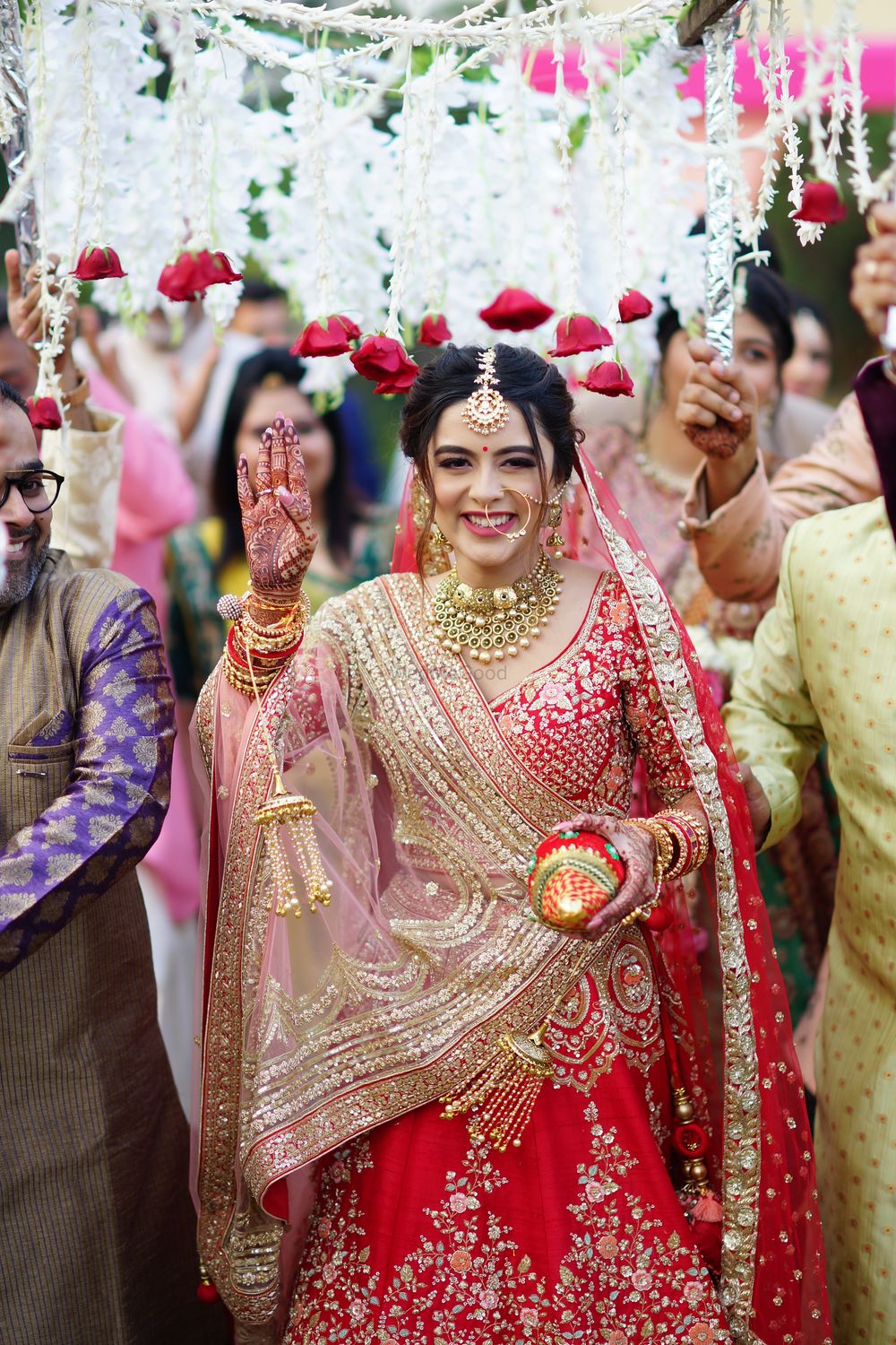 Photo of Bridal entry under a phoolon ki chaadar.