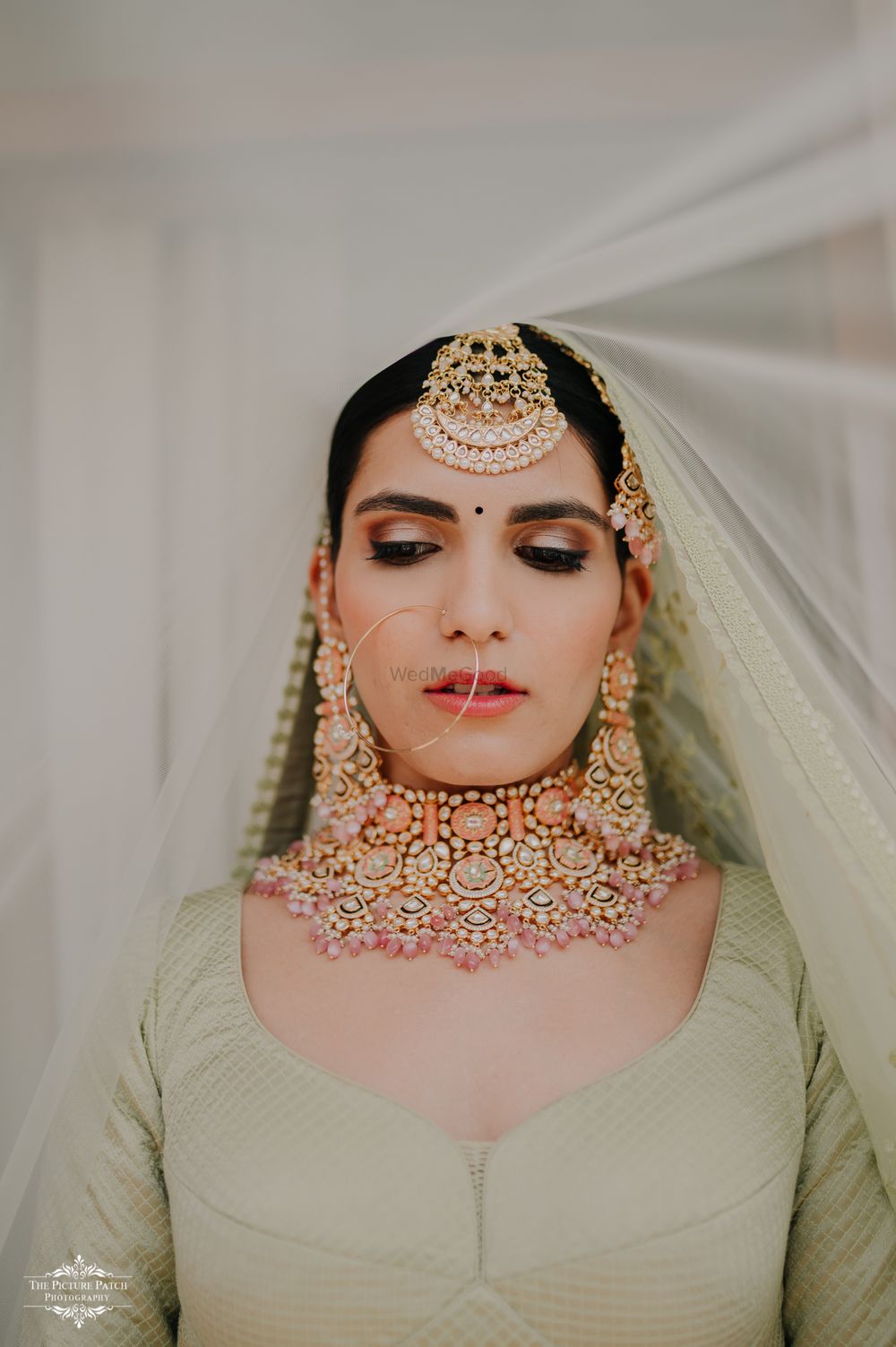 Photo of Bride wearing an enameled choker with a pastel lehenga.