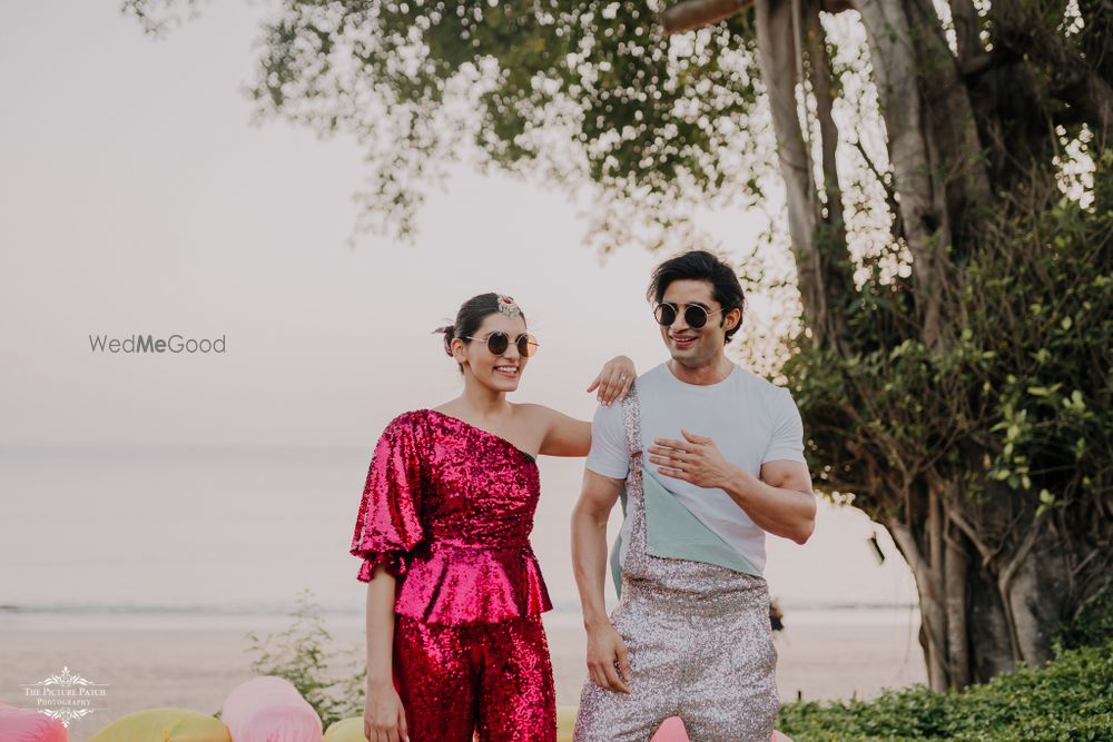 Photo of Bride and groom wearing coordinated sequinned outfits.