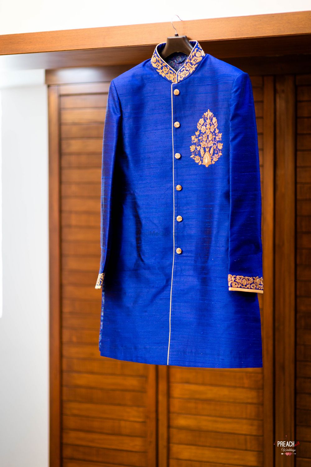 Photo of Royal Blue Sherwani on Hanger with Gold Embroidery