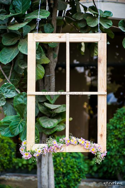 Photo of rustic wooden frames with flowers hanging for photobooth