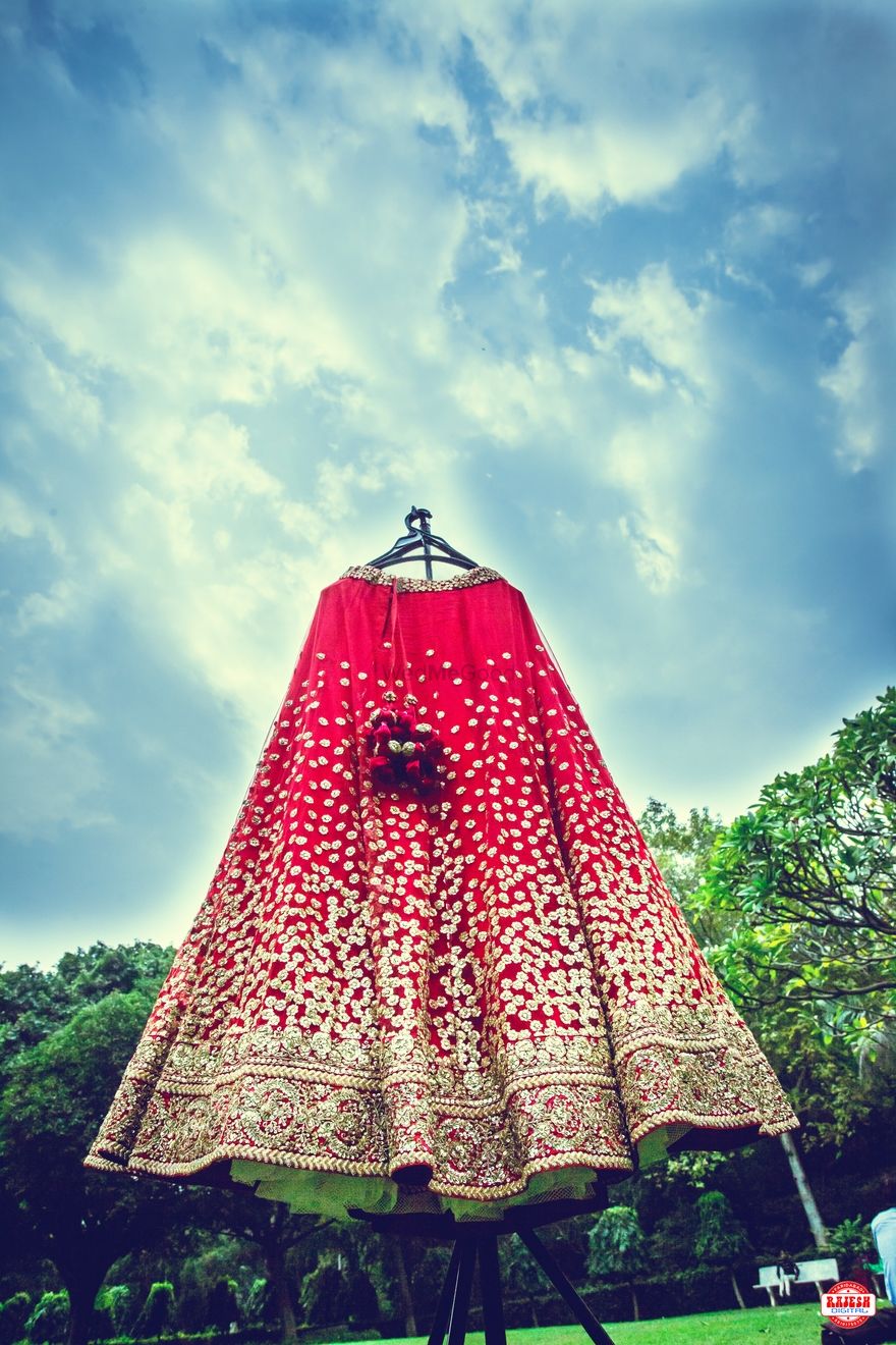 Photo of Red Lehenga with Sequin Work on Hanger on Easel