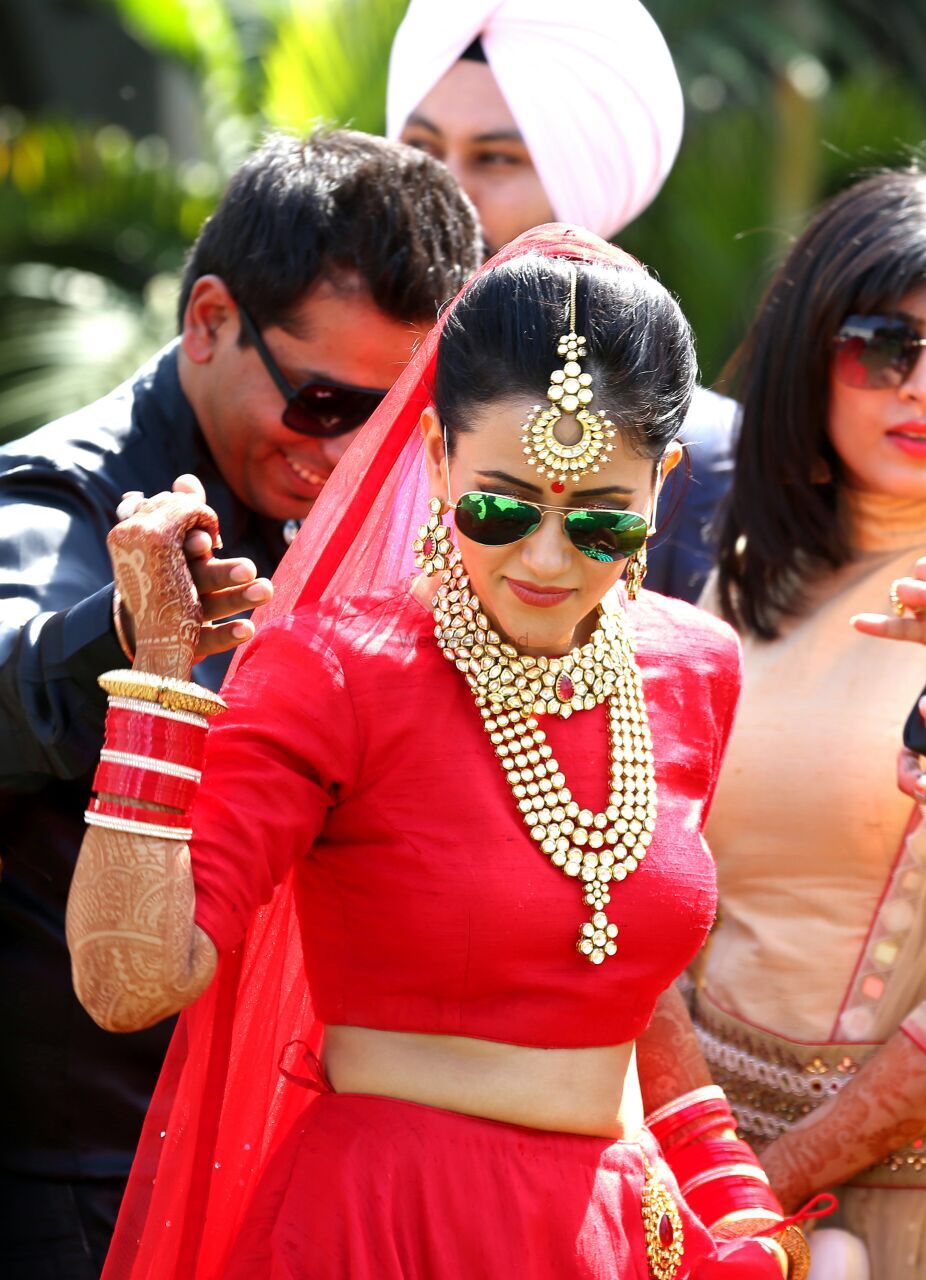 Photo of Bride in Red Lehenga with Sunglasses at Wedding
