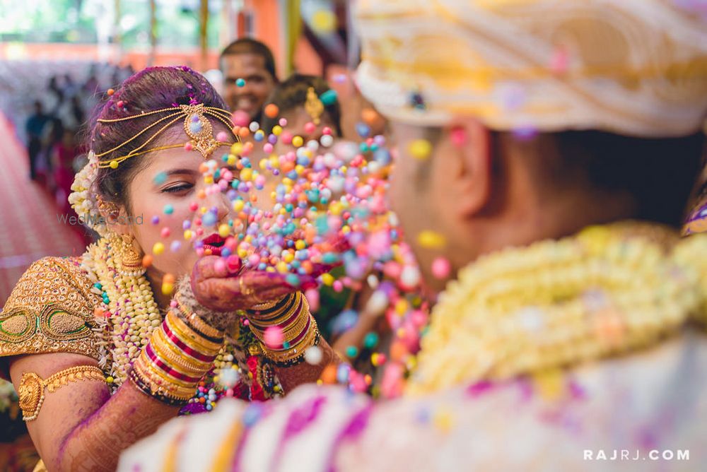 Photo of Bride Blowing Confetti Balls on Groom