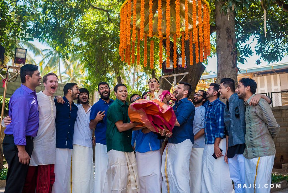 Photo of South indian wedding with Groomsmen picking bride