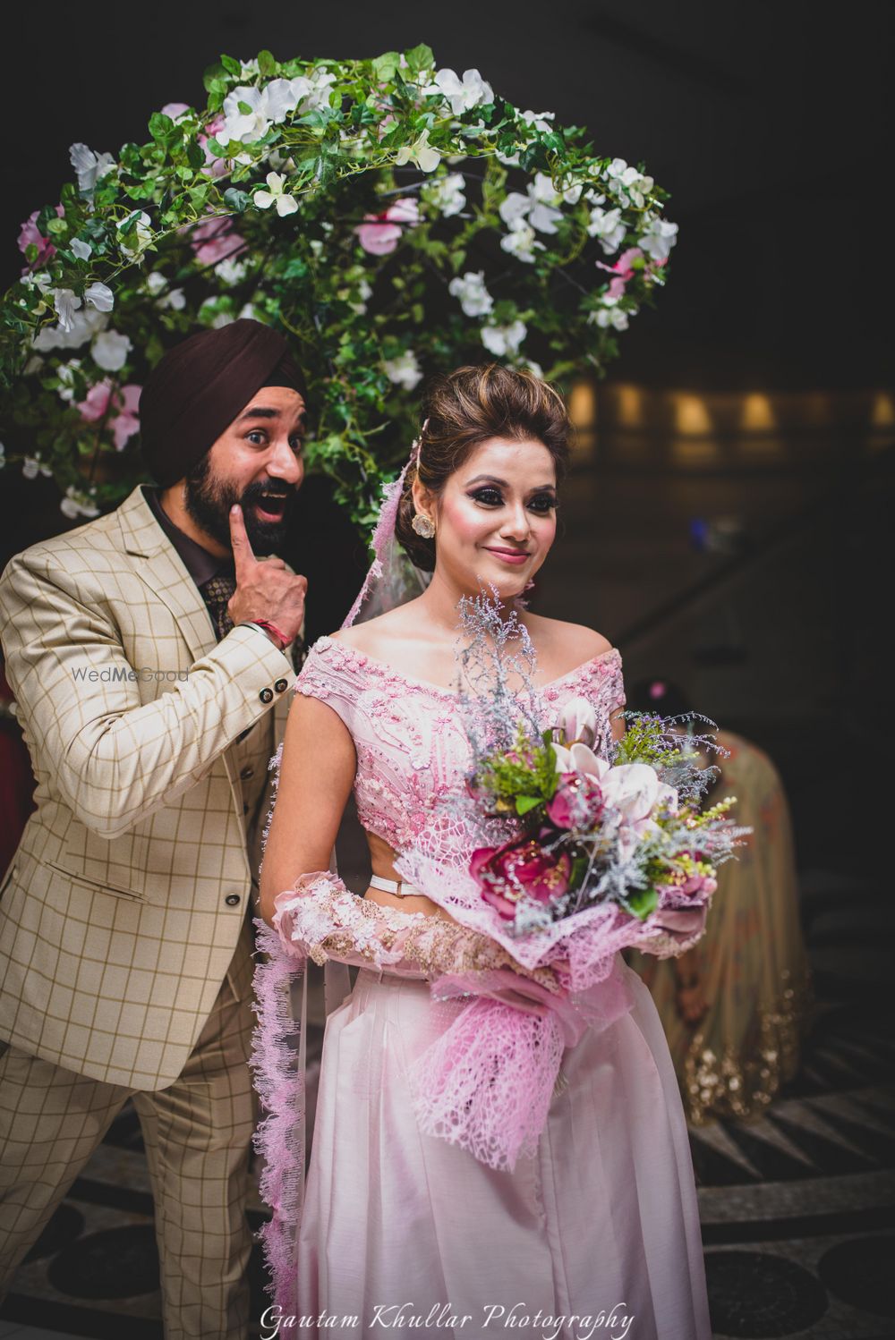 Photo of Bride entering under floral umbrella