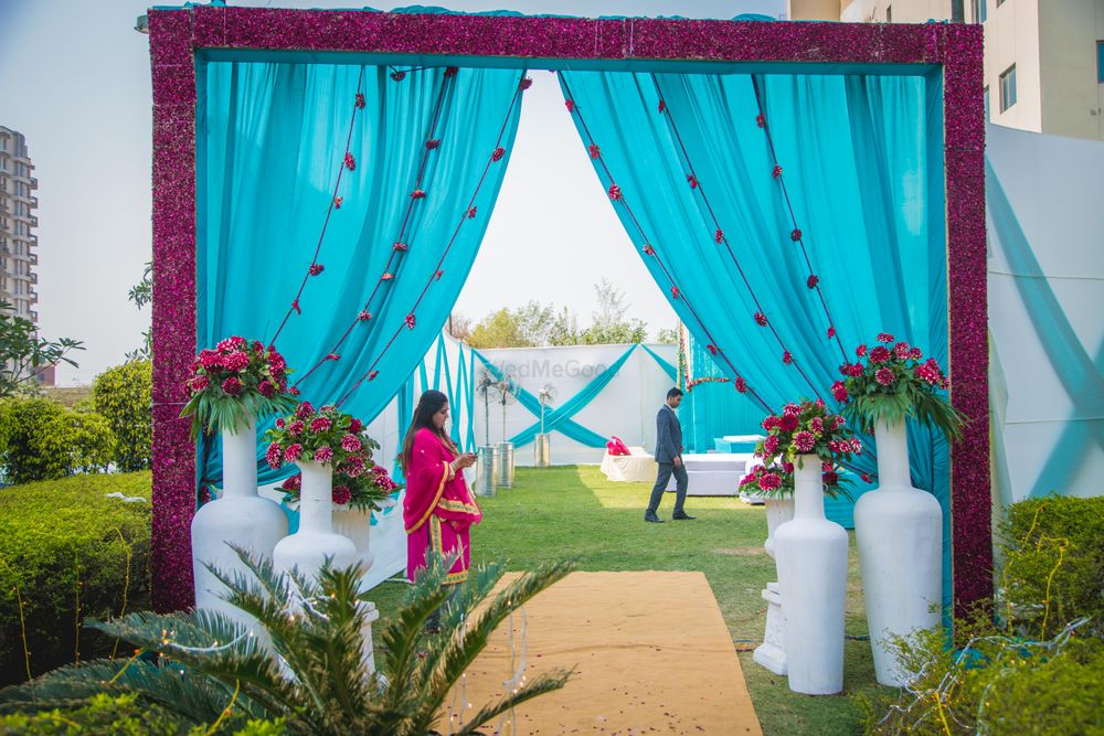 Photo of Bright blue and pink theme entrance decor with curtains