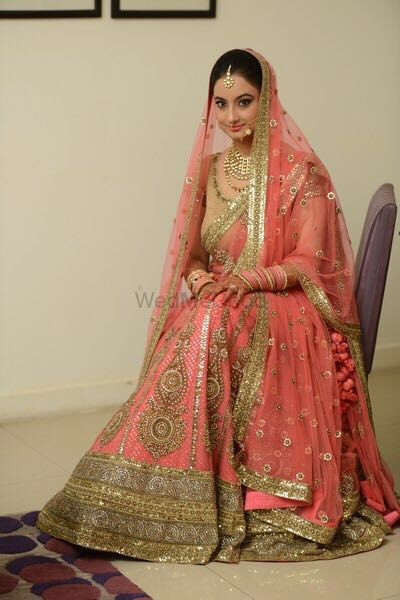 Photo of Peach and gold bridal lehenga with thread work