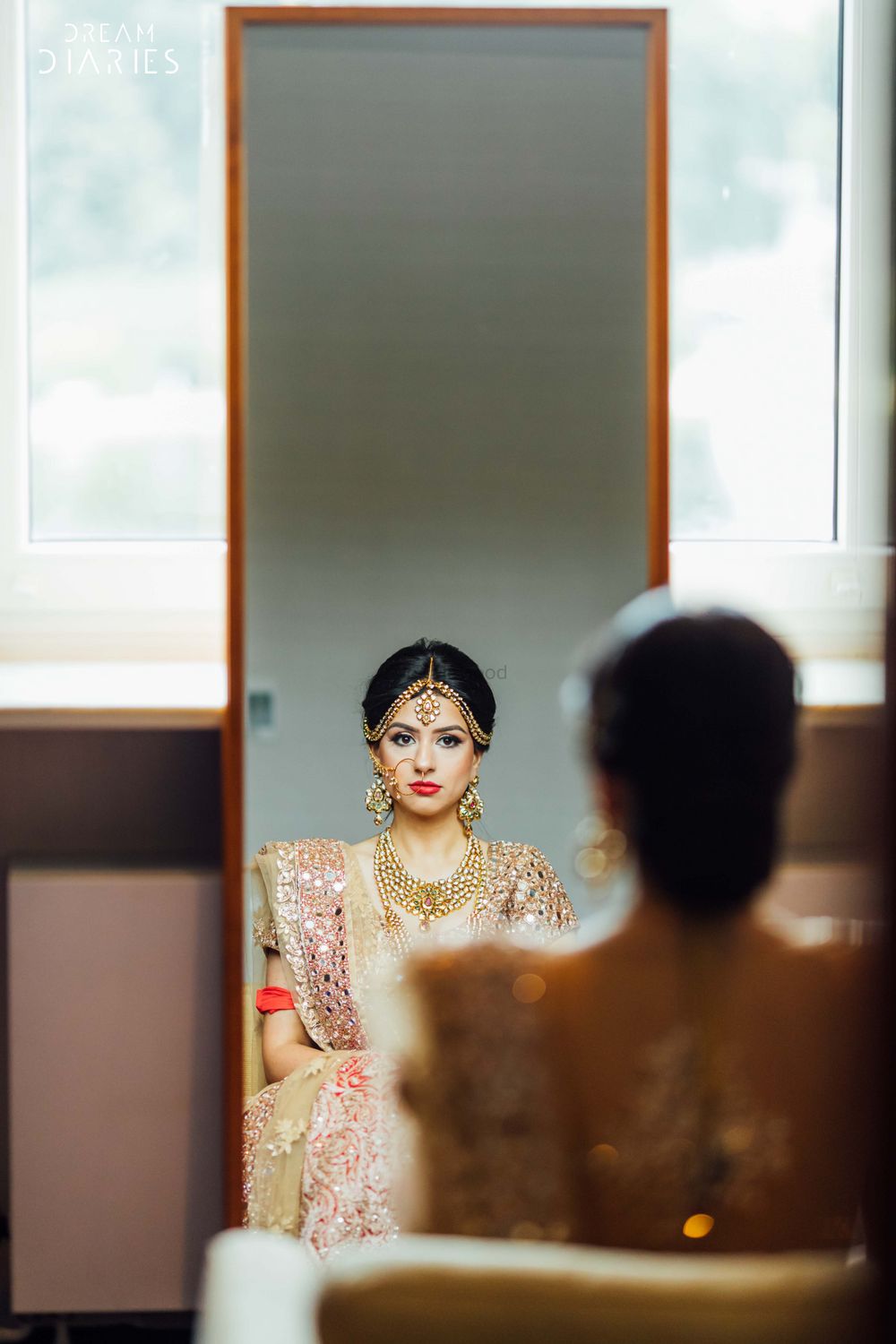 Photo of Bride looking at herself in the mirror