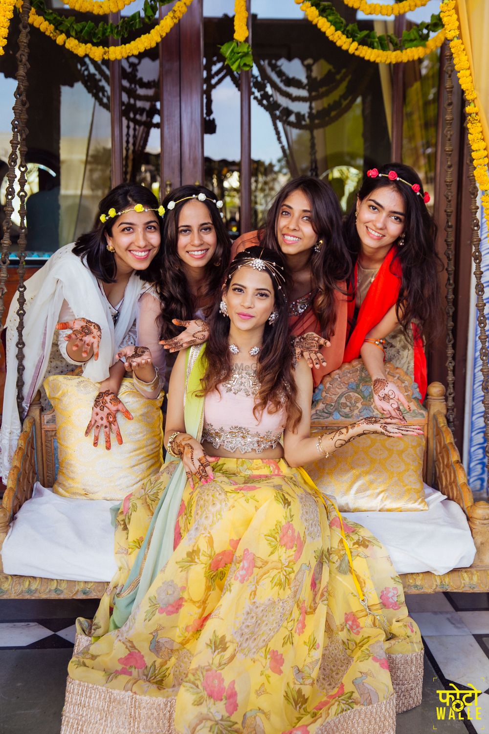 Photo of Bride and bridesmaids on mehendi with wreaths