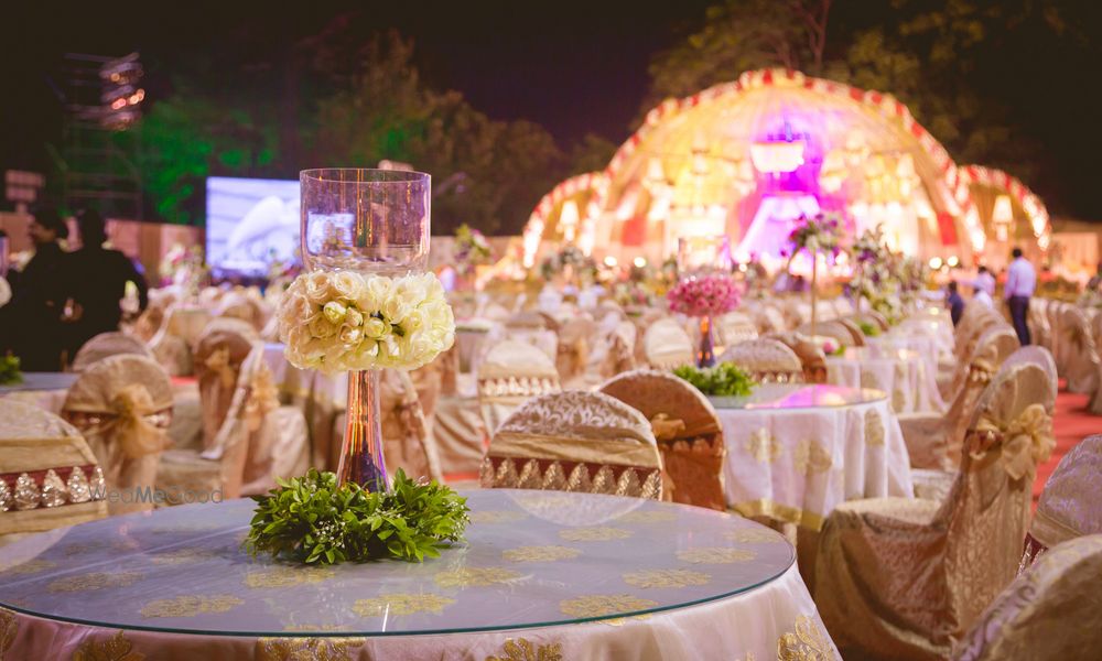 Photo of Table centerpieces made of glass with flowers and roses all around