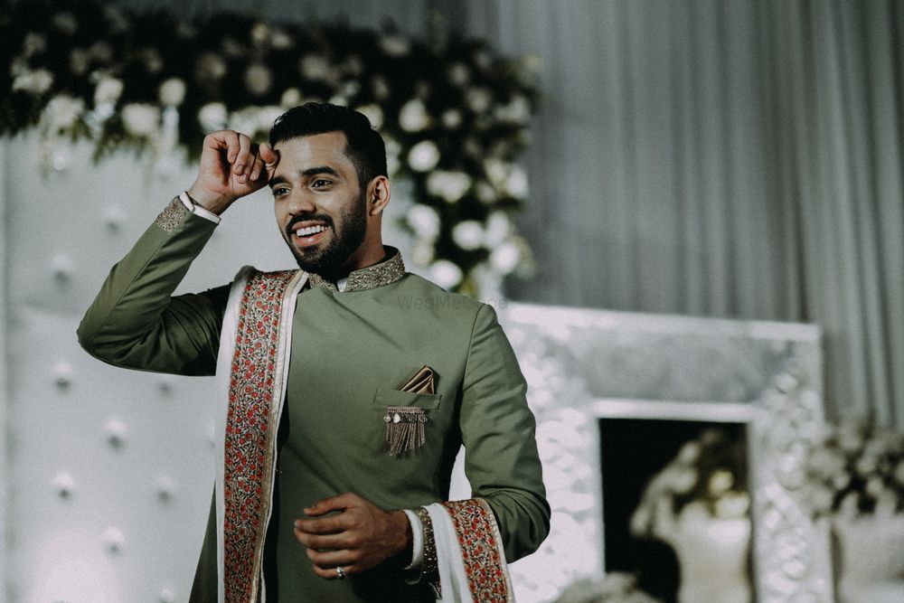 Photo of Groom wearing a sage green bandhgala with white stole