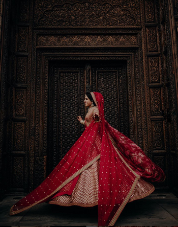 Photo of Pretty twirling shot of a bride in a red lehenga