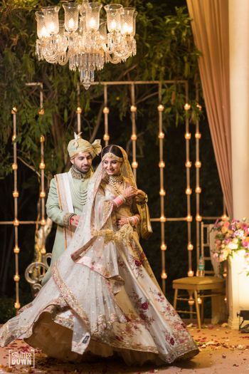 Couple portrait with twirling bride in floral print lehenga