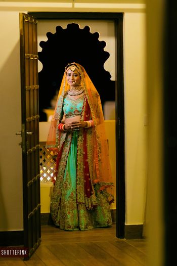 Photo of Red and green bridal lehenga offbeat shade