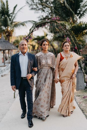 Photo of A bride enters with her parents on her wedding day