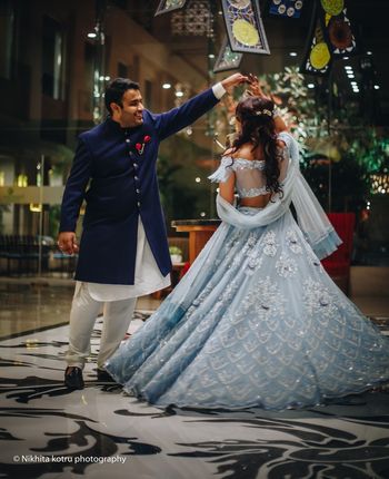 Photo of Twirling bride and groom in shades of blue