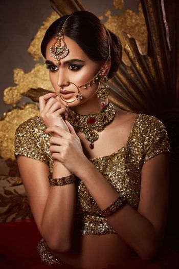 Gold bridal look with maangtikka and nath