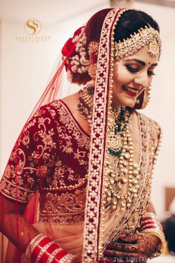 Gorgeous bride wearing maroon blouse with polki and emeralds jewelry 