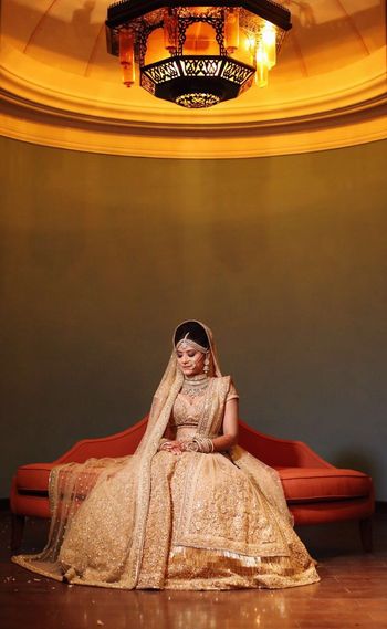 Photo of Bridal portrait of bride in gold lehenga