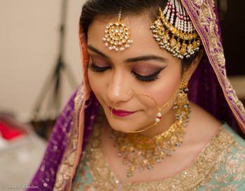 Bride Wearing Gold and Pearl Nath Jhoomer Maangtikka