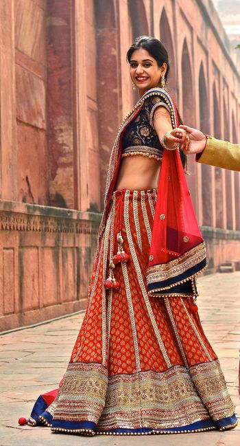 Photo of red and blue banarsi print lehenga