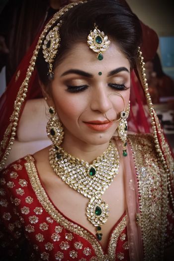 Photo of A bride in red lehenga with kundan jewelry