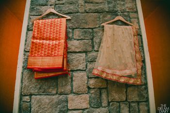 Photo of Orange and Gold Saris on a Hanger