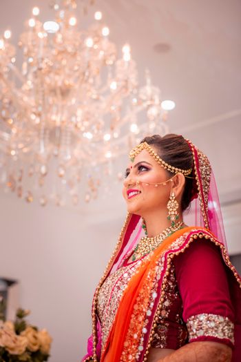 Happy glowing bride shot in orange lehenga 