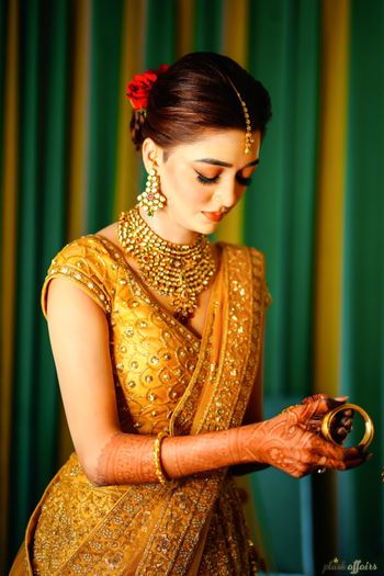 Photo of A bride in a golden lehenga getting ready