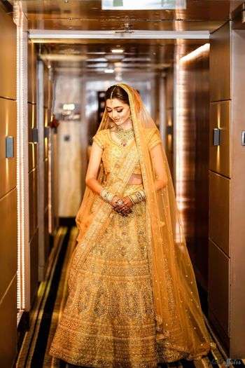 Photo of A bride in a gold lehenga