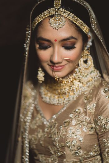 Close up shot of a bride in gold lehenga.