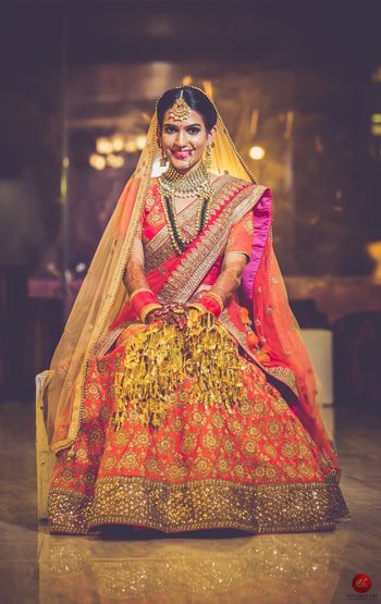 Orange and gold bridal lehenga with pink dupatta