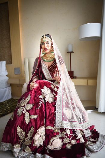 Photo of Winter wedding bridal lehenga in maroon with silver motifs
