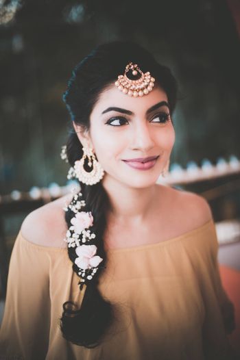 Photo of Side braid with roses and babys breath in hair for mehendi