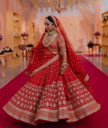 bride twirling in a red lehenga 