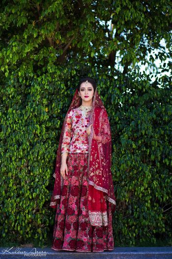 Photo of Offbeat bride in floral bridal lehenga