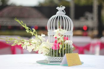 birdcage with floral arrangements