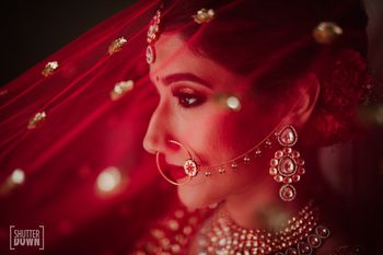 Photo of Bridal portrait with red dupatta as veil