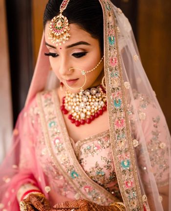 Photo of Bride in pink lehenga with red jewellery