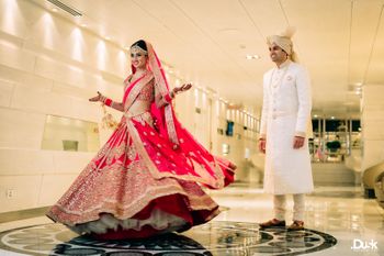 Photo of Red bridal lehenga by Sabyasachi worn by twirling bride