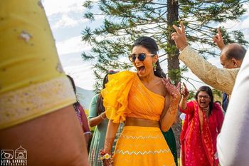 Photo of Bride wearing a one-shoulder blouse with a matching skirt.