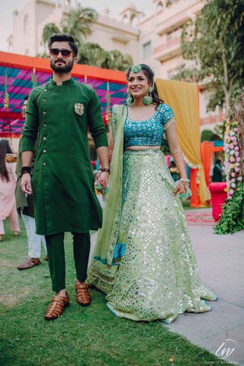 Bride and groom on mehendi in contrasting outfits of same shade