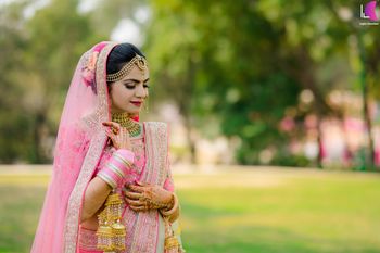 A beautiful bride dolled up in a light pink lehenga on her wedding. 