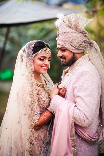 A romantic couple holding on each other beautifully dressed in pink outfits on their wedding. 