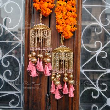 Light pink kaleere with tassels on it 