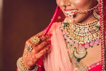 Photo of A bride in pink lehenga with pink and gold necklace