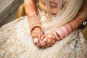 bridal hands with pastel outfit and cocktail rings on wedding