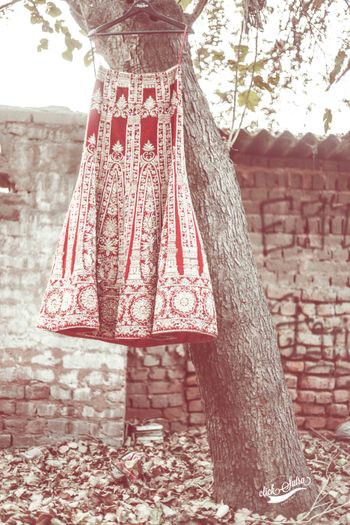 Photo of Red and Gold Bridal Lehenga on a Hanger